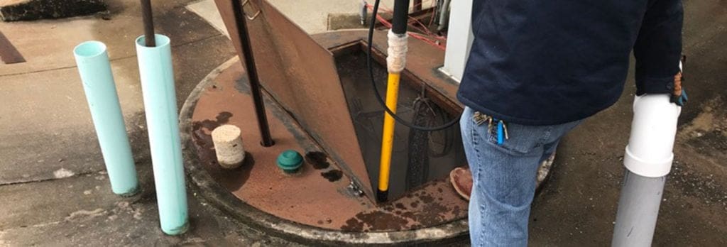 Man working on underground plumbing system.