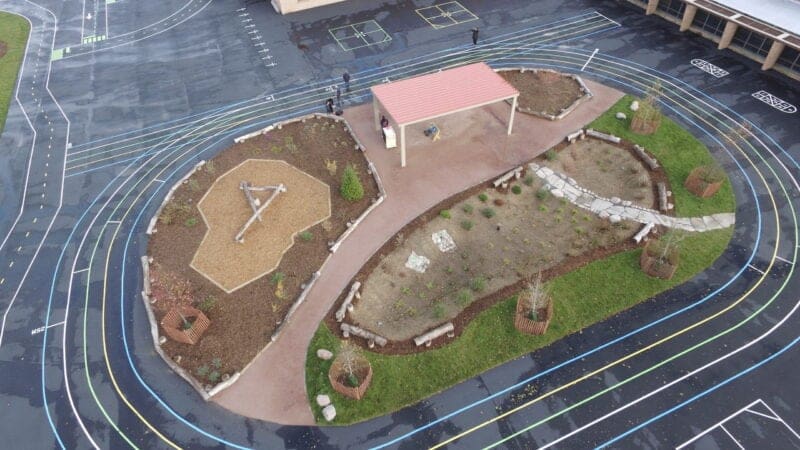 Aerial view of schoolyard including a track around an outdoor classroom