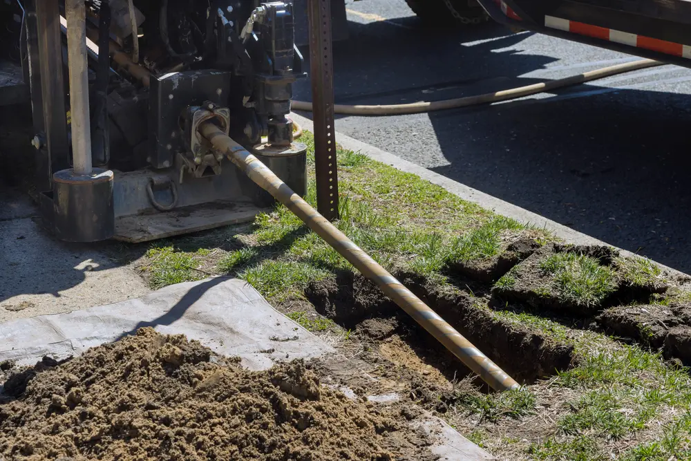 Low angle view of trenchless sewer repair, fiber optic and water pipes with horizontal directional drilling technology machine work process