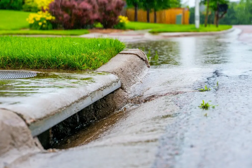 Stormwater flowing into street intake drain after a rainstorm