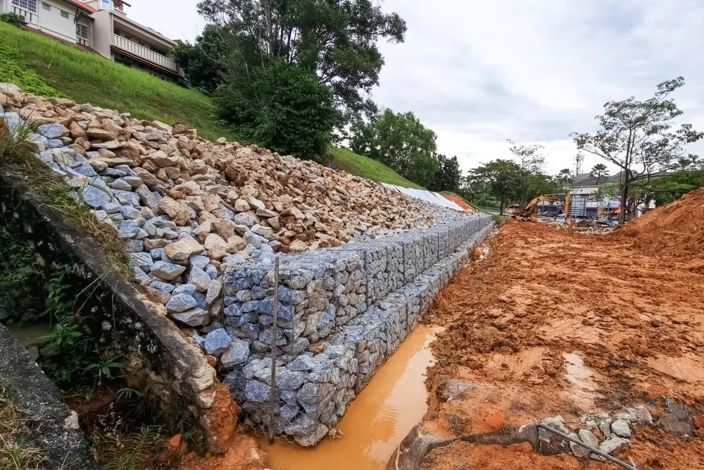 Permit Review & Regulatory Requirement Assessments - AQUALIS Series of slope retention construction design with rocks and mesh to manage landslide