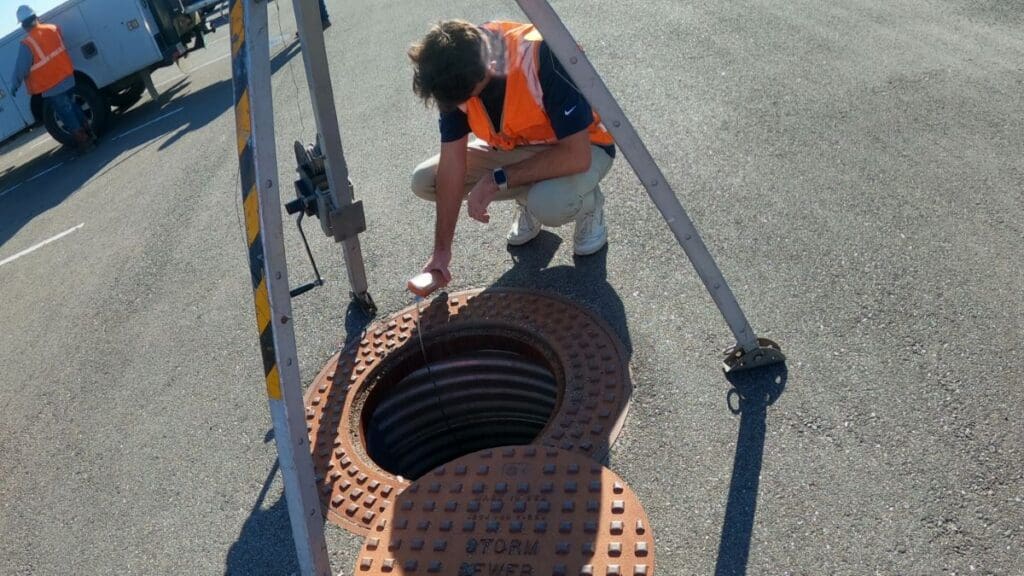person inspecting a storm sewer